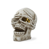 Skull-shaped decorative item with a hand covering one eye on a white background