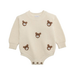 Beige baby romper with teddy bear appliqués on a white background