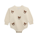 Beige baby romper with teddy bear appliqués on a white background