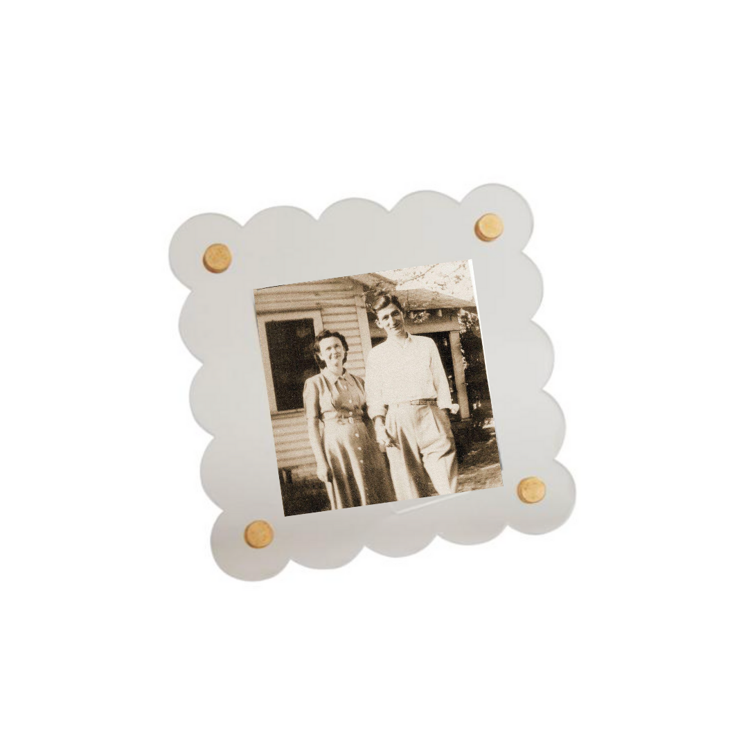 Decorative photo frame with scalloped edge holding a black and white photograph of two people.