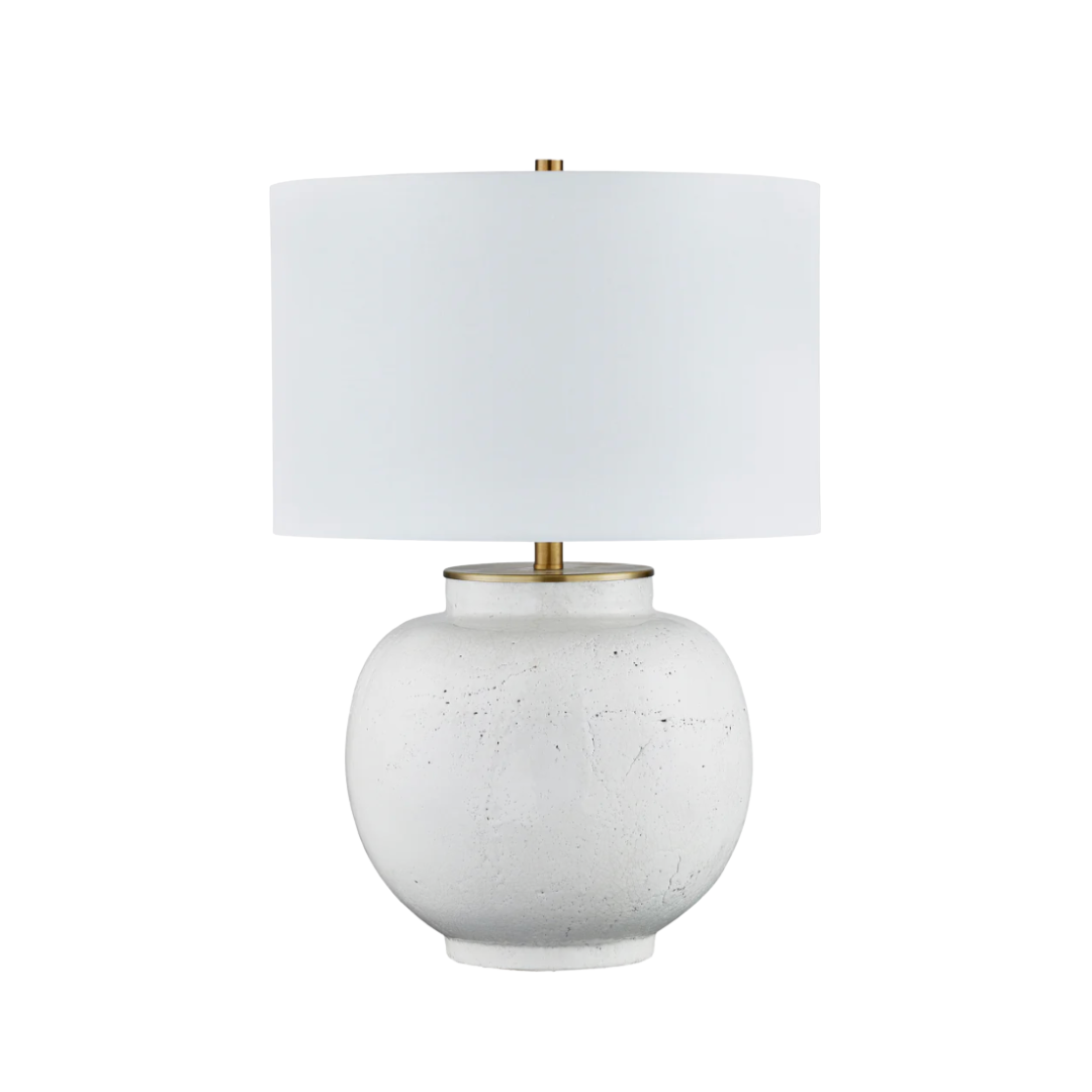 Table lamp with a white ceramic base and a white fabric shade on a white background