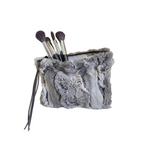 Gray fur makeup bag with brushes on a white background