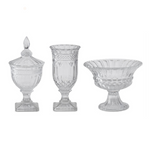Set of three clear glass decorative items on a white background