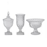 Set of three clear glass decorative items on a white background