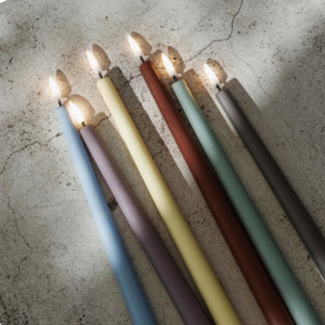 Set of colorful candles on a textured surface
