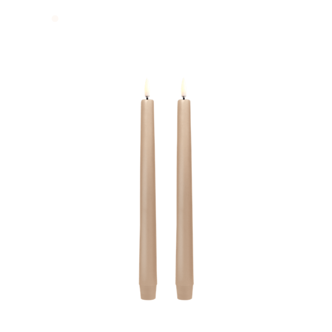 Two beige candles on a white background