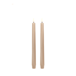 Two beige candles on a white background