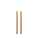 Two beige candles on a white background