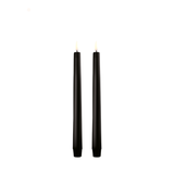 Two black candles on a white background