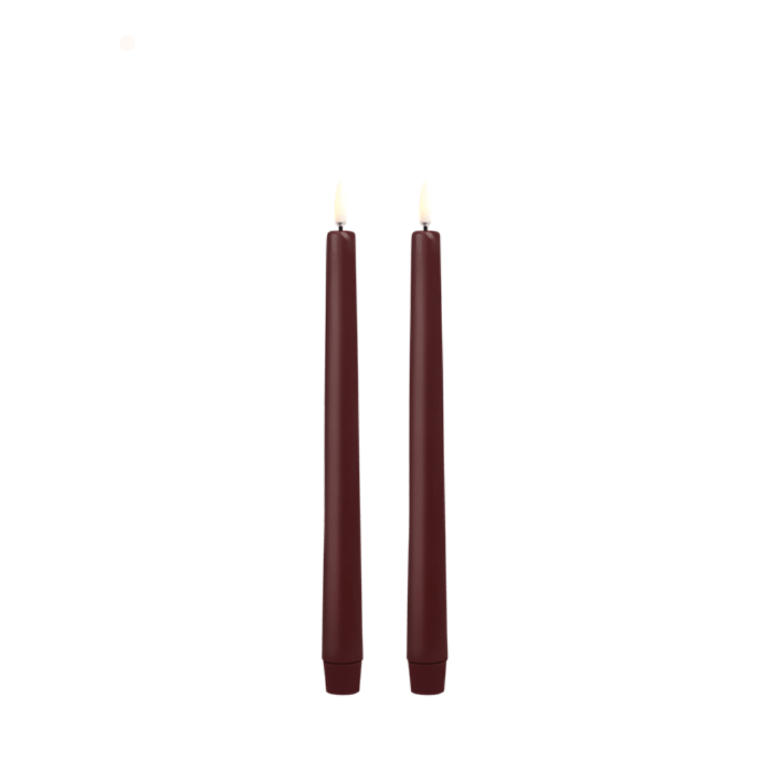 Two burgundy candles on a white background