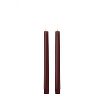 Two burgundy candles on a white background