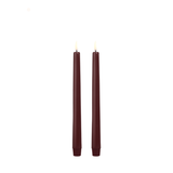 Two burgundy candles on a white background
