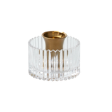 Clear glass candle holder with gold base on a white background