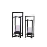 Two black metal candle holders with glass containers on a white background