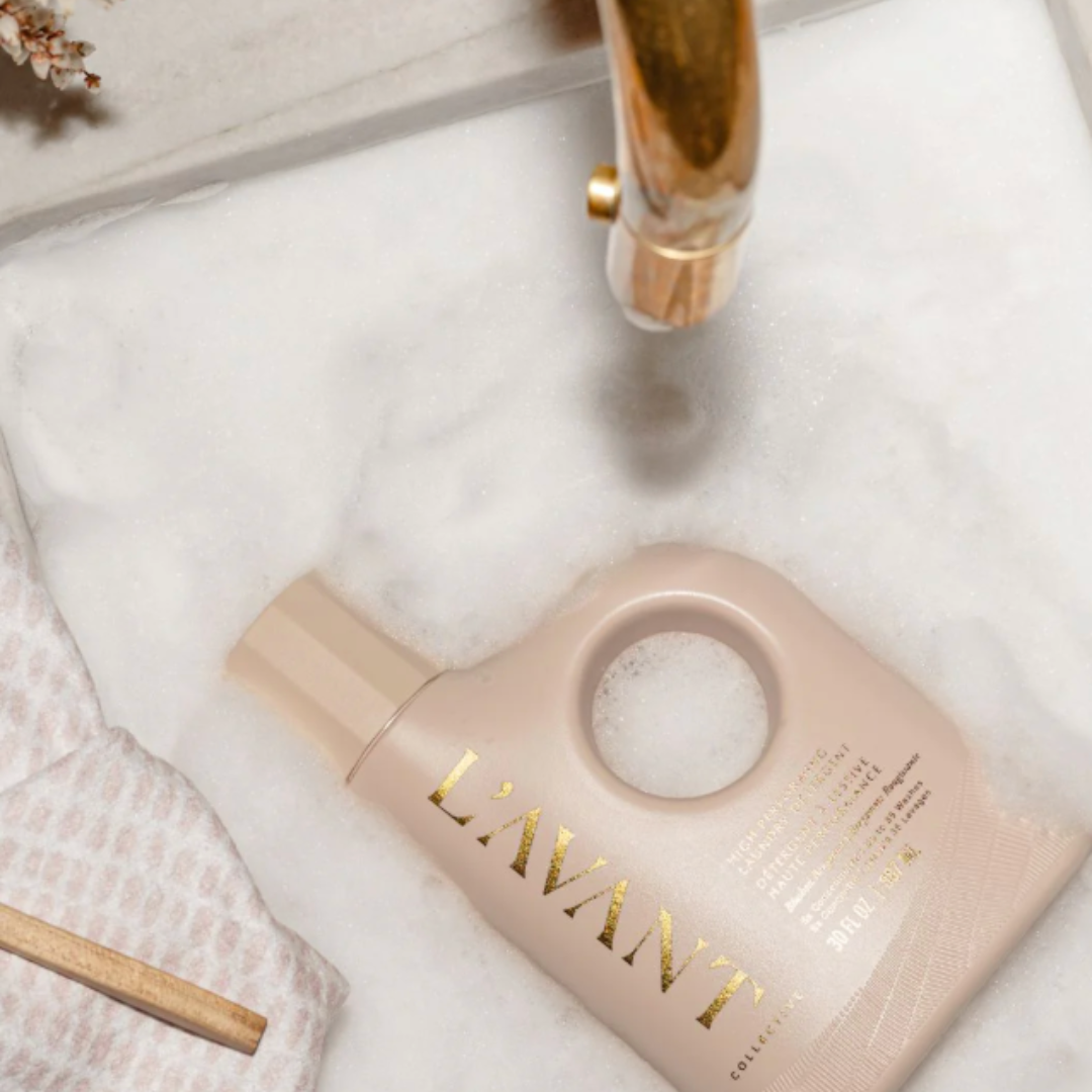 LAVANT skincare bottle on a white towel with a gold faucet in the background