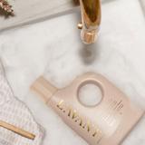 LAVANT skincare bottle on a white towel with a gold faucet in the background