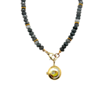 Necklace with black and gray beads and a gold pendant on a white background