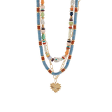 Layered beaded necklace with turquoise, and gold beads, featuring a gold heart pendant and mixed textures on a white background