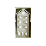 Minimalist white porcelain nativity scene with 11 handcrafted figures, including Mary, Joseph, Baby Jesus, Wise Men, animals, and a star-topped stable, displayed beside an eco-friendly kraft gift box