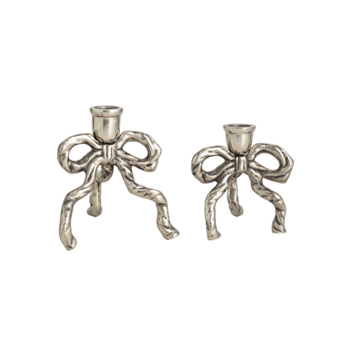 Two silver bow-shaped candle holders on a white background