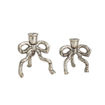 Two silver bow-shaped candle holders on a white background