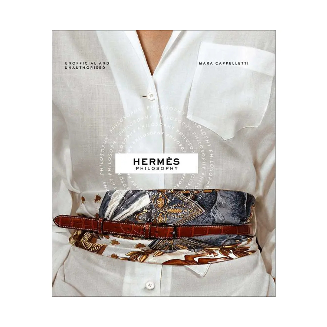Book titled 'Hermès Philosophy' by Mara Cappelletti with a person wearing a white shirt and patterned belt.