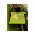 book cover with Green handbag with 'PARIS' written on it, held by a person wearing a green coat.
