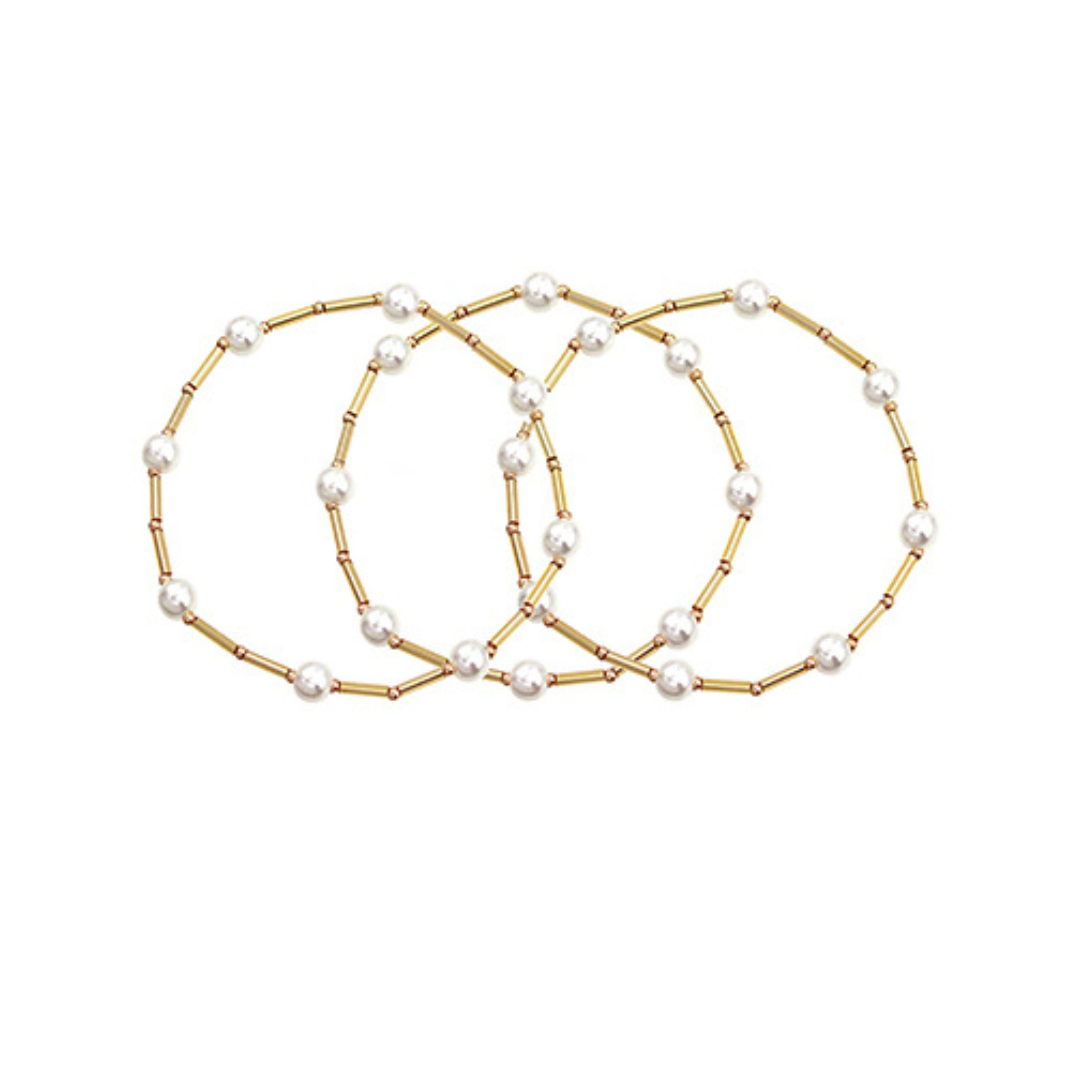 Three pearl bracelets with gold accents on a white background