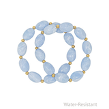 Blue beaded bracelet with gold accents on a white background