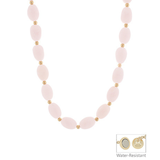 Necklace with pink beads and gold accents on a white background
