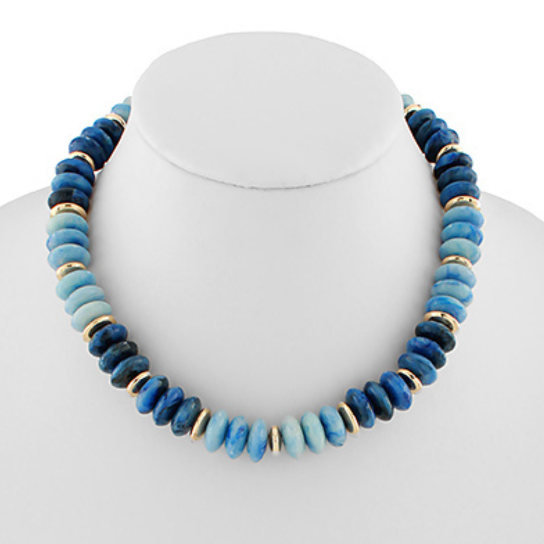 Blue beaded necklace on a mannequin with a white background