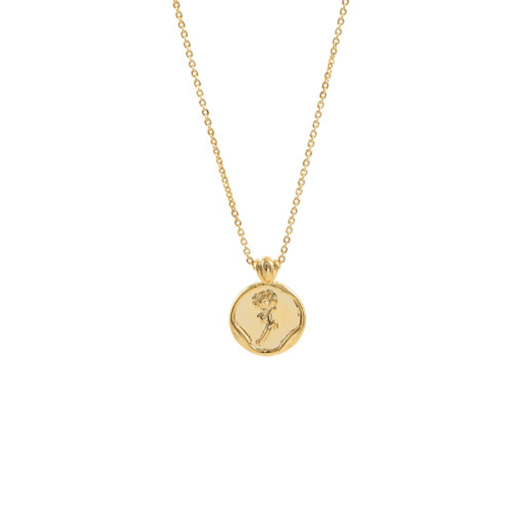 Gold necklace with a round pendant on a white background