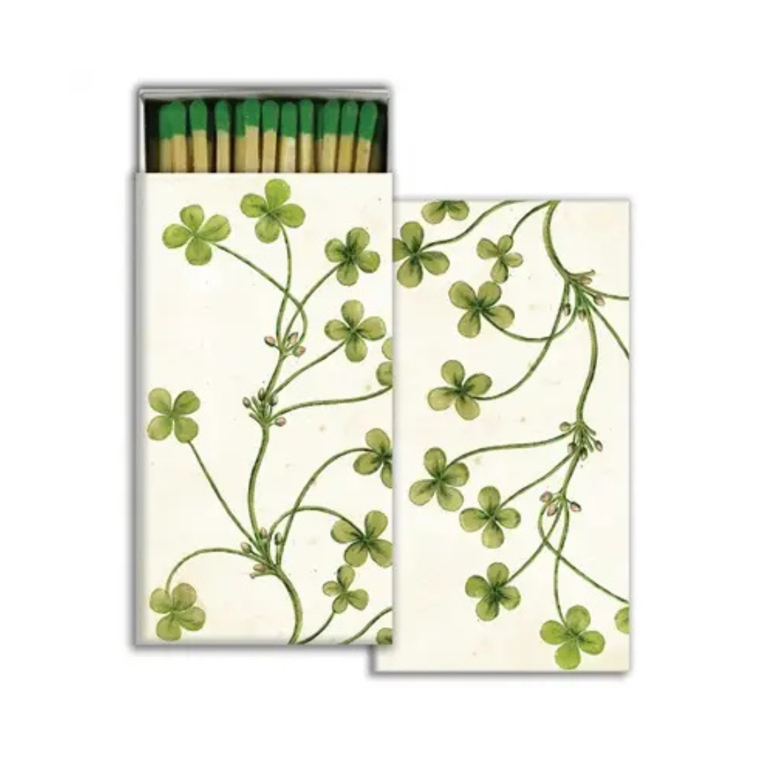 Matchbox with green clover design on a white background