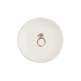 White ceramic ring dish with a rose gold ring design on a white background