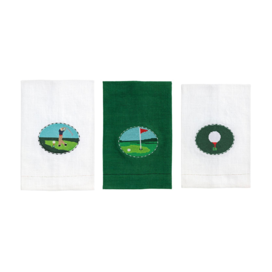 Three golf-themed towels with different designs on a white background