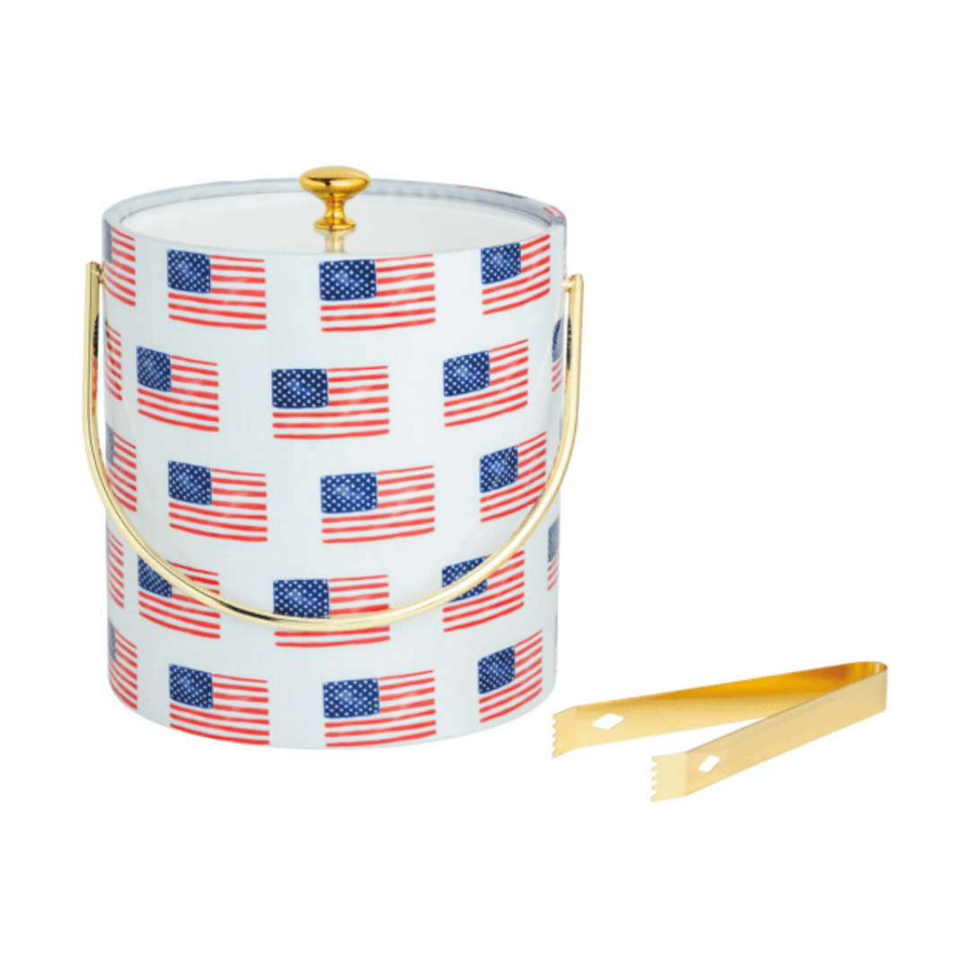 Ice bucket with American flag pattern and gold tongs on a white background