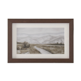 Framed landscape painting of a road leading to mountains on a white background
