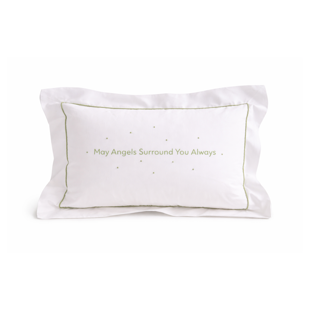 White pillow with embroidered green text on a white background