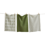 Three textured green dishtowels hanging on a clothesline against a white background