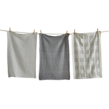 Three textured gray dishtowels hanging on a clothesline against a white background
