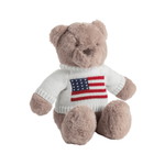 Plush teddy bear wearing a sweater with an American flag design on a white background