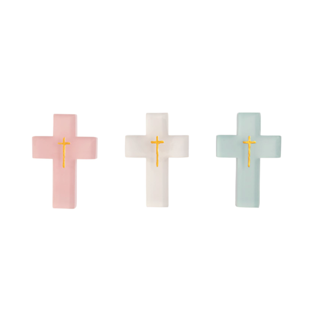Three cross-shaped resin cross in pink, white, and light blue on a white background