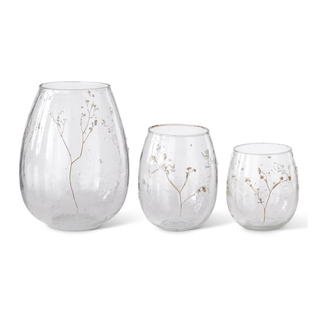 Three clear glass vases with floral designs on a white background