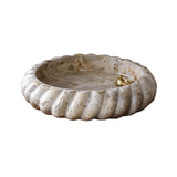 Decorative stone bowl with ribbed design on a white background