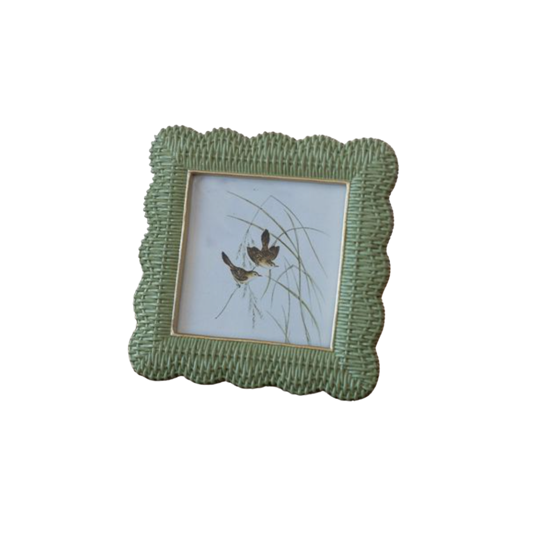 Green wicker picture frame with a small photo of birds on a white background