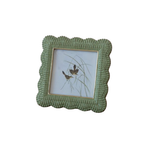 Green wicker picture frame with a small photo of birds on a white background