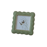 Green wicker picture frame with a small photo of birds on a white background