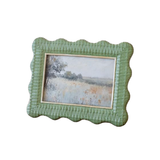Green textured picture frame with a landscape painting inside on a white background