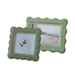 Two green textured picture frames with scenic prints on a white background