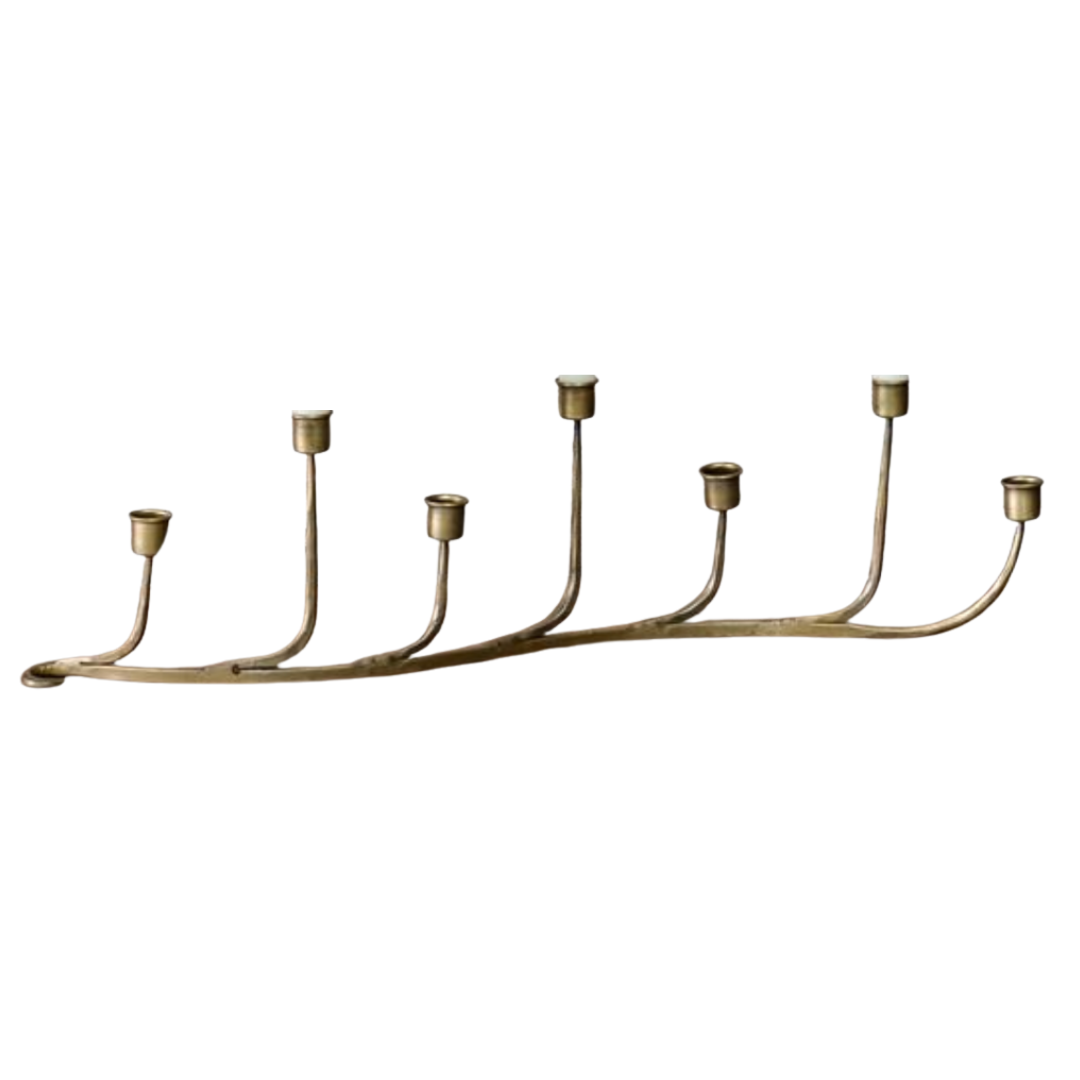 Brass candle holder with seven candle holders on a white background